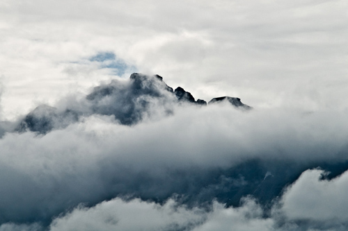 Photo of clouds hugging a Norwegian mountain peak