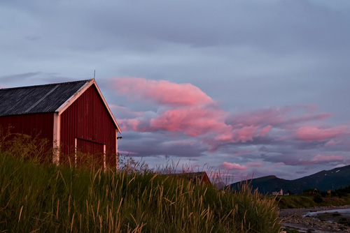 Photo of red sunset clouds and red boatshed