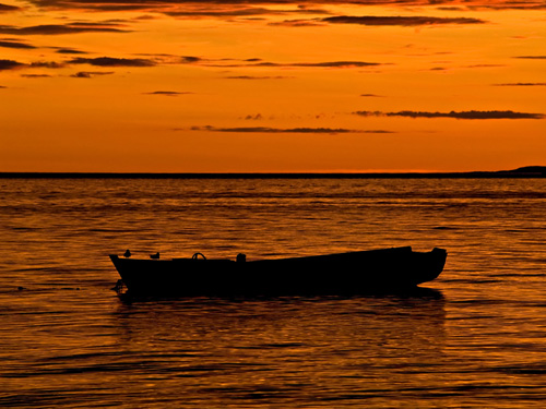 Photo of old rowboat at sunset on a Norwegian fjord 