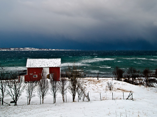 Picture of barn in Northern Norway against a stormy ocean