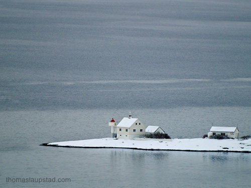 Picture of lighthouse on a snow covered headland in Norway