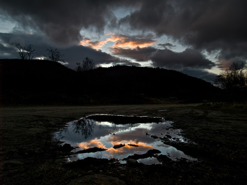 Photo of sunset reflection in a puddle