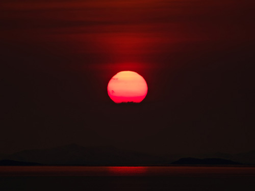 Zoomed in picture of the sun setting in the ocean in Northern Norway