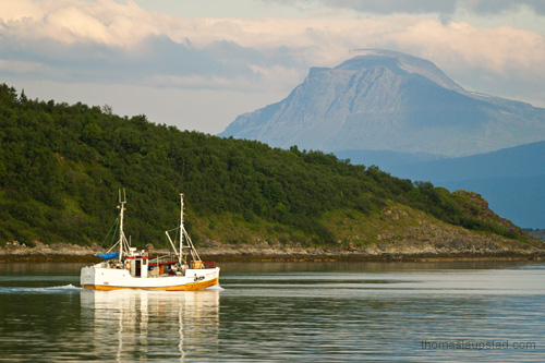 Photo of old wooden fishing boat on the sea by Harstad in Northern Norway